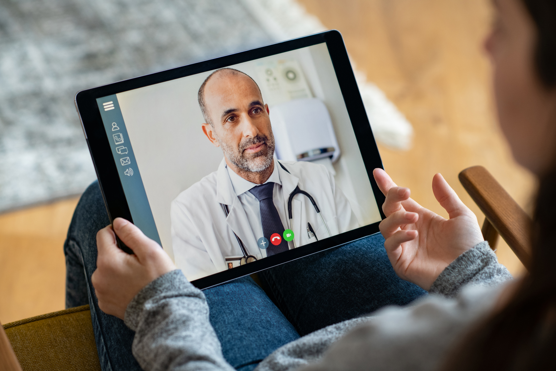Patient qui consulte son médecin à distance par l'intermédiaire d'une tablette, en visio-conférence.